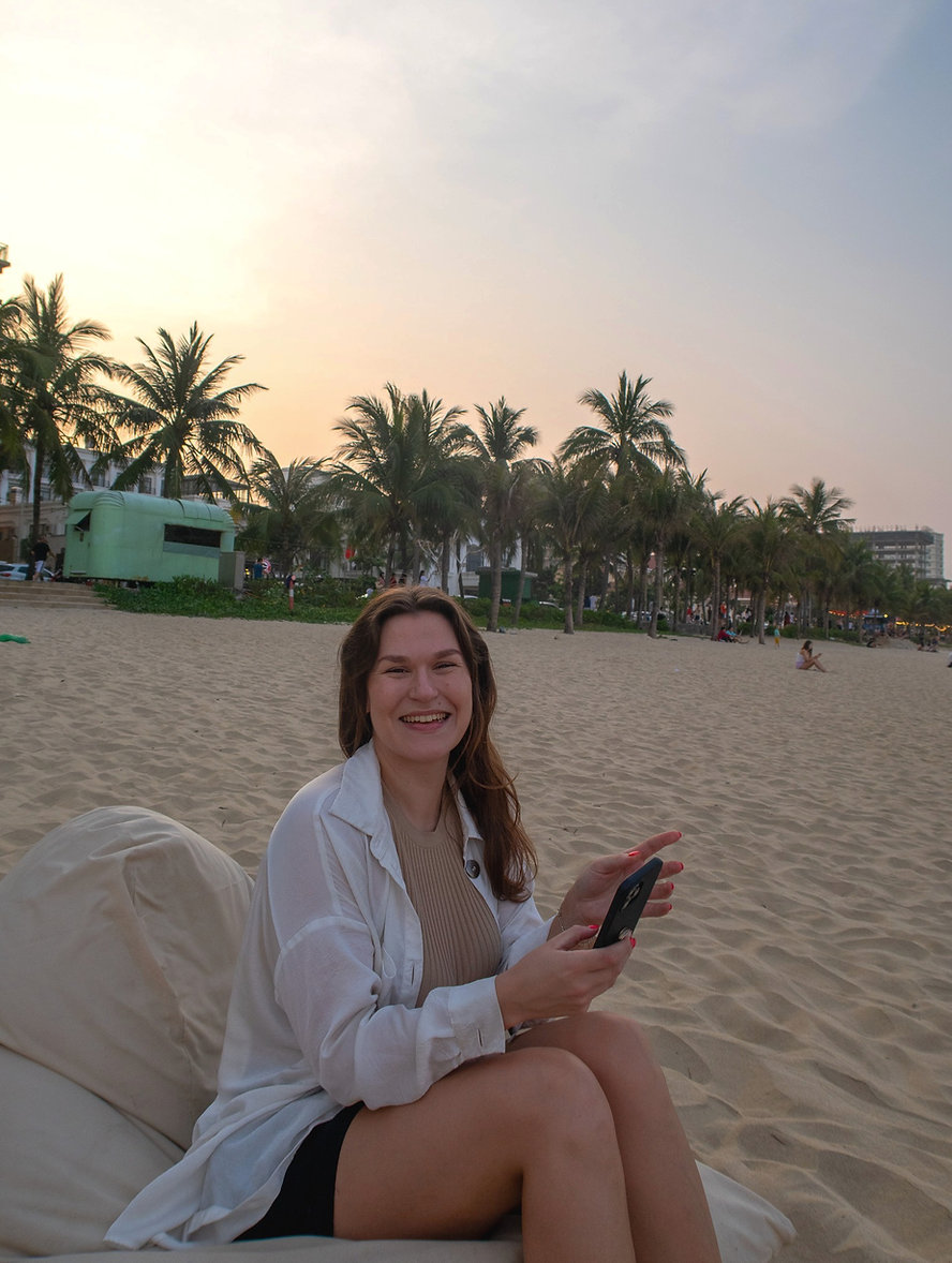 Ebba Fogdal på stranden med mobilen i handen